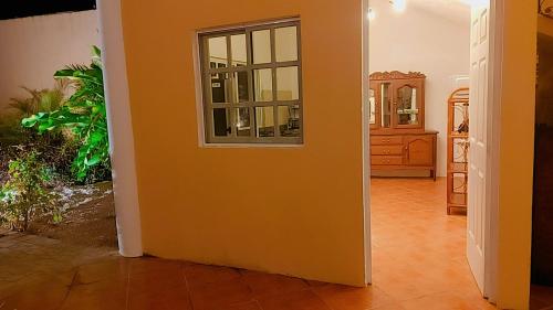 a room with an orange wall and a window at Quinta Eva and Ivan in Kanasín