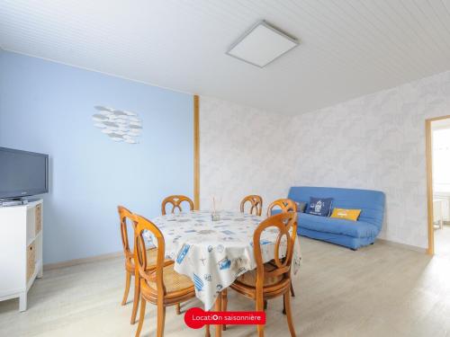 - une salle à manger avec une table, des chaises et un canapé bleu dans l'établissement Maison Familiale à Châtelaillon-Plage, 800m de la plage, 3 chambres, Jardin clôturé, Proche La Rochelle - FR-1-535-57, à Châtelaillon-Plage