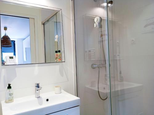 une salle de bain avec une douche, un lavabo et un miroir dans l'établissement Maison familiale 7 personnes, près du port du Logeo, jardin, terrasse, parking, plage à proximité - FR-1-639-120, à Sarzeau