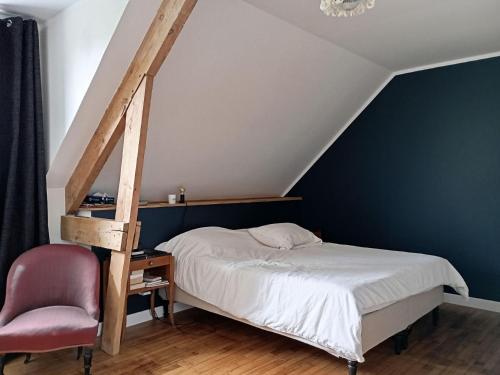 une chambre avec un lit et une chaise dans l'établissement Maison familiale 7 personnes, près du port du Logeo, jardin, terrasse, parking, plage à proximité - FR-1-639-120, à Sarzeau