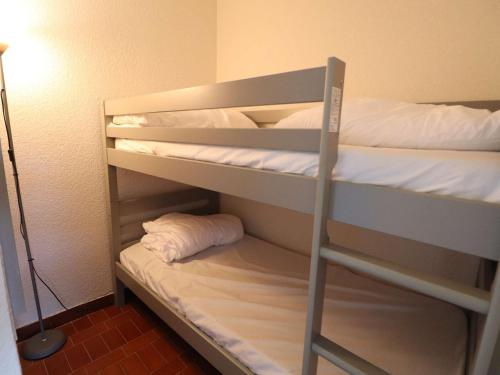 Ce lit se trouve dans un dortoir doté de 2 lits superposés et d'une lampe. dans l'établissement Studio avec piscine, parking et terrasse à Port Camargue - FR-1-307-262, au Grau-du-Roi