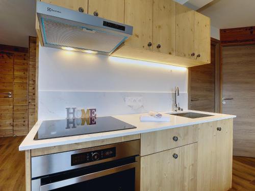 une cuisine avec un évier et une cuisinière four supérieur dans l'établissement Courchevel 1850: Appart refait 2022, ski-ski out, 7 pers, balcon, parking - FR-1-575-221, à Courchevel