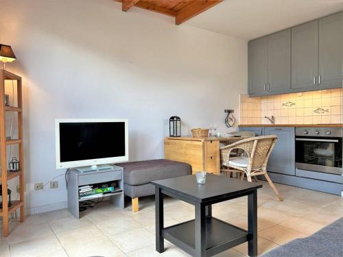 un salon avec un canapé, une télévision et une table dans l'établissement Appartement Duplex 100m Plage, Terrasse, Parking, 4 Couchages - Le Lavandou - FR-1-251-533, au Lavandou