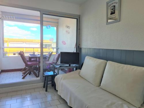 d'un salon avec un canapé et d'un balcon avec une table. dans l'établissement Appartement moderne avec piscine, 4 couchages, Cap d'Agde - FR-1-249-411, au Cap d'Agde