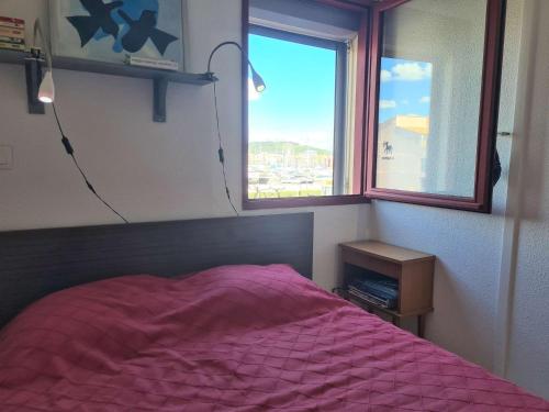 - une chambre avec un lit rose et une fenêtre dans l'établissement Appartement moderne avec piscine, 4 couchages, Cap d'Agde - FR-1-249-411, au Cap d'Agde