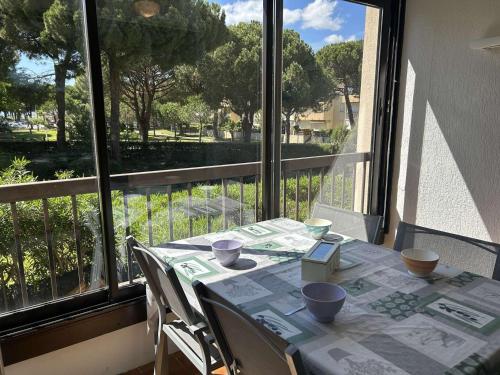 d'une table et de chaises avec vue sur un balcon. dans l'établissement T2 avec loggia, proche mer et Seaquarium, 5 couchages, ménage inclus - FR-1-250-274, au Grau-du-Roi