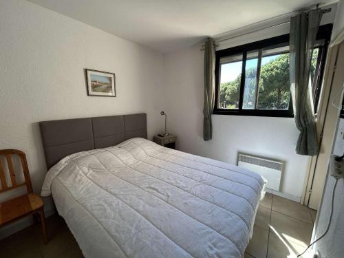 une chambre avec un grand lit et une fenêtre dans l'établissement T2 avec loggia, proche mer et Seaquarium, 5 couchages, ménage inclus - FR-1-250-274, au Grau-du-Roi