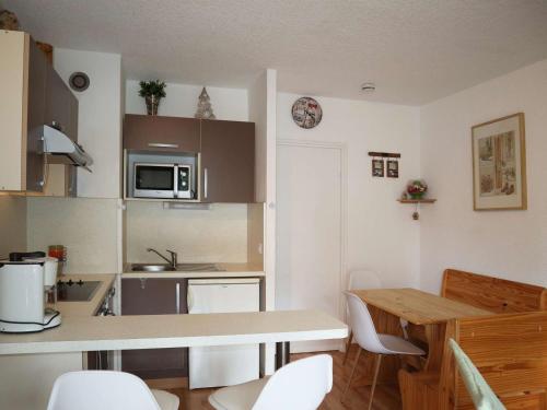 une cuisine avec une table et des chaises dans une pièce dans l'établissement Studio spacieux 4 pers aux Orres, skis aux pieds - FR-1-322-606, aux Orres