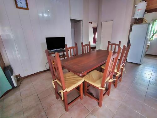 a dining room with a wooden table and chairs at Magnolia azul in Federación