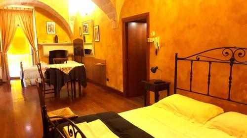 sypialnia z łóżkiem i stołem w pokoju w obiekcie Nel Centro Storico w mieście Galatina