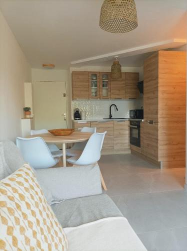 une cuisine et un salon avec une table et des chaises dans l'établissement Appartement avec piscine, à Sète