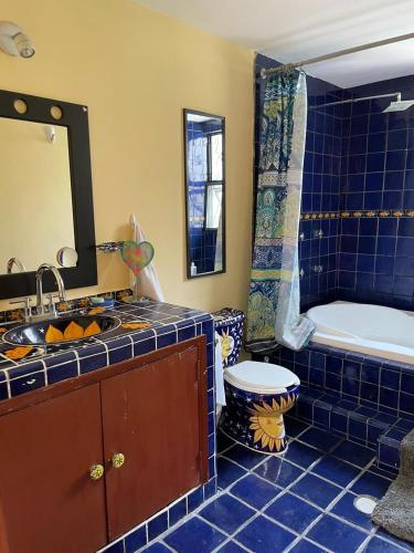 a blue tiled bathroom with a tub and a sink at Urban Oasis in Mexico City