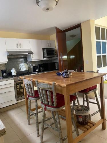 a kitchen with a wooden table and chairs at Urban Oasis in Mexico City