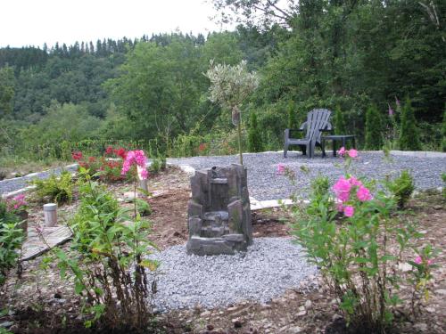 a stone bench sitting in a garden with flowers at Holiday Home Pandora in Bouillon
