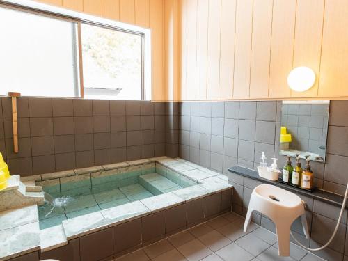 a bathroom with a tub and a shower at Nozawa Onsen Azegamikan in Nozawa Onsen