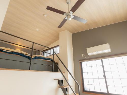 a bedroom with a bunk bed and a ceiling fan at Nozawa Onsen Azegamikan in Nozawa Onsen