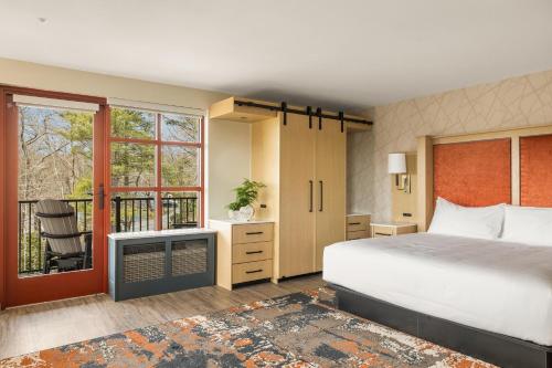 ein Schlafzimmer mit einem großen Bett und einem Fenster in der Unterkunft The Embers Hotel in Blowing Rock