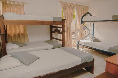 three bunk beds in a room with a window at Marias House - Magnifique Apartments in Santa Marta