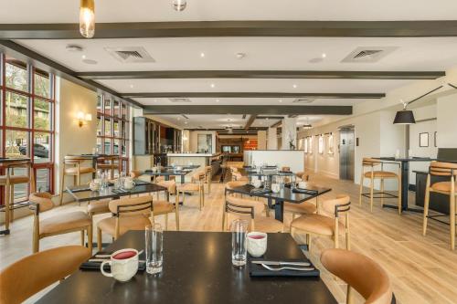 a restaurant with tables and chairs in a room at The Embers Hotel in Blowing Rock