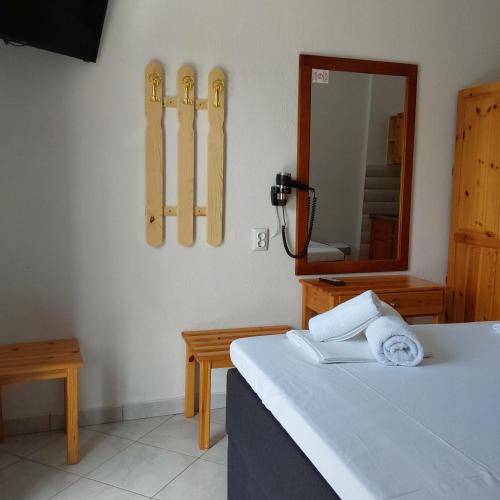 a bedroom with a bed with a mirror and skis on the wall at ANNA MARIA Studios in Potos