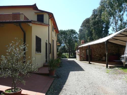 a building with a walkway next to a house at PODERE OSLAVIA AZ.AGR.BIO GIANNINI in Alberese