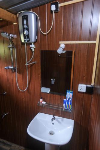 a bathroom with a sink and a mirror at Lion Wood Treehouse in Talkote