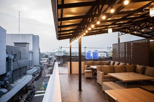 a rooftop patio with couches and tables on a building at Miki House in Chumphon