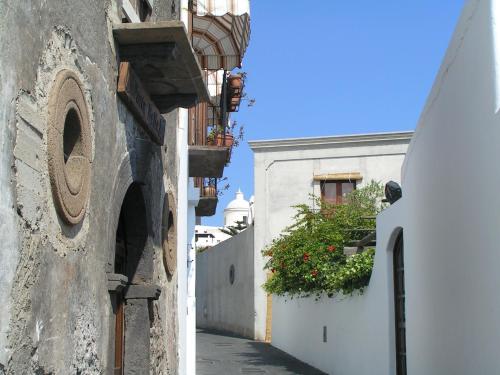 an alley with white buildings and a flower pot at Villa Mareblu Luxury Holiday Apartment direttamente sul mare in Stromboli