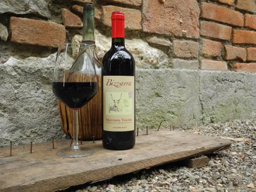 a bottle of red wine next to a glass of wine at PODERE OSLAVIA AZ.AGR.BIO GIANNINI in Alberese