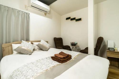 a bedroom with a white bed with a towel on it at 58, Higashi-Horikiri 2, private house rental, 東堀切2 in Tokyo