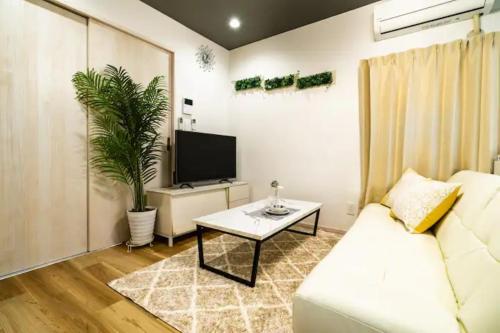 a living room with a white couch and a tv at 58, Higashi-Horikiri 2, private house rental, 東堀切2 in Tokyo
