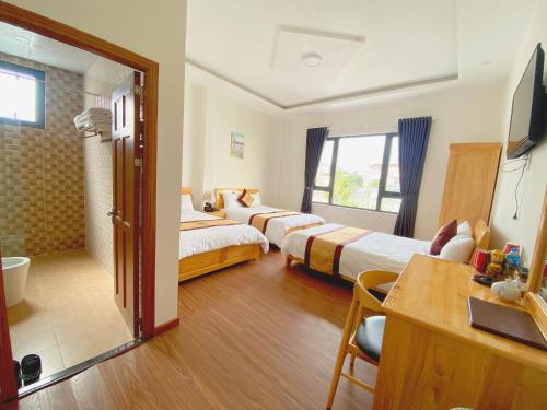 una camera d'albergo con due letti e una televisione di HANZ Hoa Dang Hotel a Da Lat