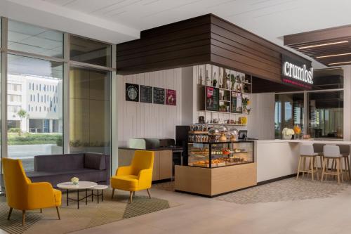 a restaurant with yellow chairs and a counter at Holiday Inn Dubai Business Bay by IHG in Dubai