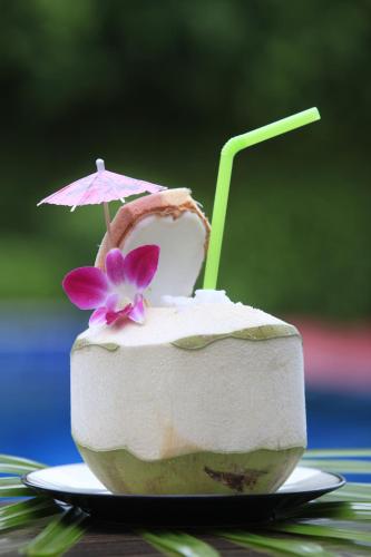 a coconut dessert with an umbrella on a plate at Palm Coco Mantra in Lamai
