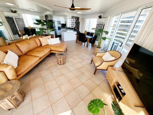 a living room with a brown couch and chairs at 19th Avenue on the Beach in Gold Coast