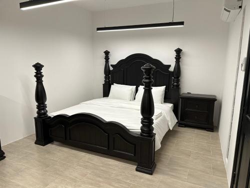 una camera da letto con letto nero, lenzuola e cuscini bianchi di Korean Hotel Resort a Tây Ninh
