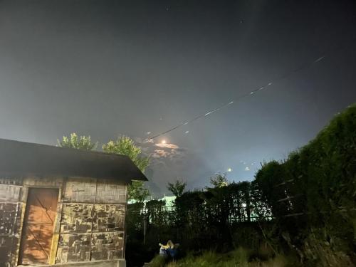 a kite flying in the sky over a house at KLhomestay in Hāpoli