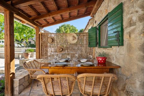 Kalpic Suites & Villa في لازوفاك: طاولة وكراسي خشبية على الفناء