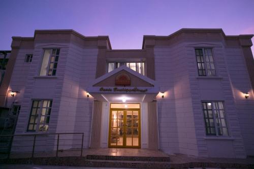 a large white building with a door at night at Oasis Boutique House in Saipan