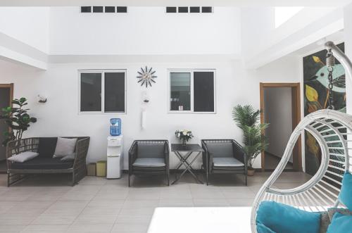 a living room with chairs and a table at Oasis Boutique House in Saipan