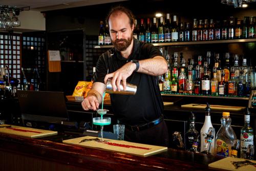 a man is making a drink at a bar at Comfort Resort Waters Edge in Port Macquarie