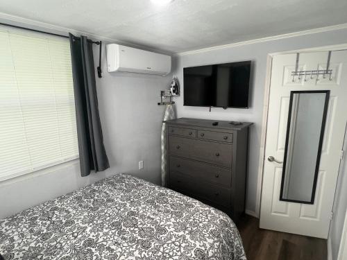 a bedroom with a bed and a dresser with a television at Gold Star in Plant City