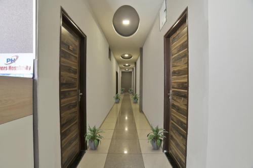 a hallway with wooden doors and potted plants at Collection O Hotel Heritage in Indore