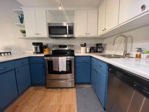 a kitchen with blue cabinets and stainless steel appliances at Condo in Palmas Del Mar - 5 min walk to Palmanova Plaza in Playa de Guayanes