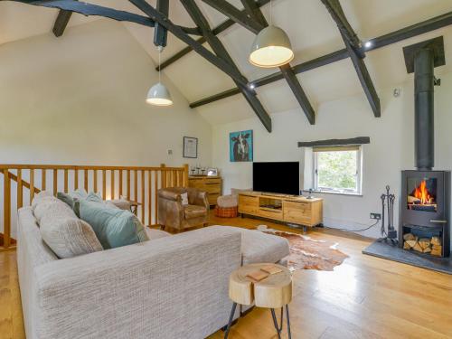 a living room with a couch and a fireplace at Pond Cottage in Newton Abbot
