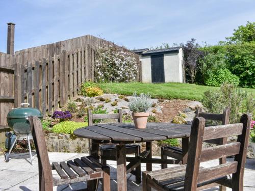 a wooden table and chairs in a garden at Pond Cottage in Newton Abbot