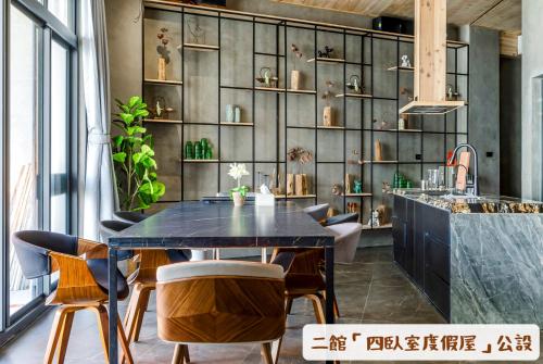 uma sala de jantar com uma mesa preta e cadeiras em 墾丁船帆石原宿 l 國旅卡特約 l 可包棟民宿 em Eluan