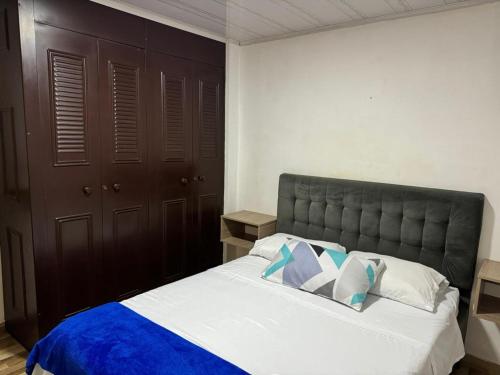 een slaapkamer met een groot bed en een blauwe deken bij Alojamiento Villasofia in Armenia