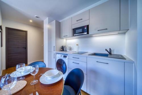 une cuisine avec une table en bois et des chaises bleues dans l'établissement #GQ Le Beau Mallifaud, à Grenoble