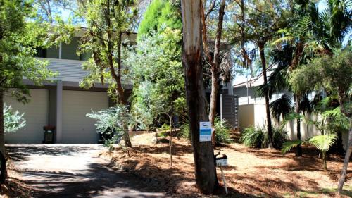 a house with a lot of trees in front of it at 'lillipillies On Dolphin' in Hawks Nest
